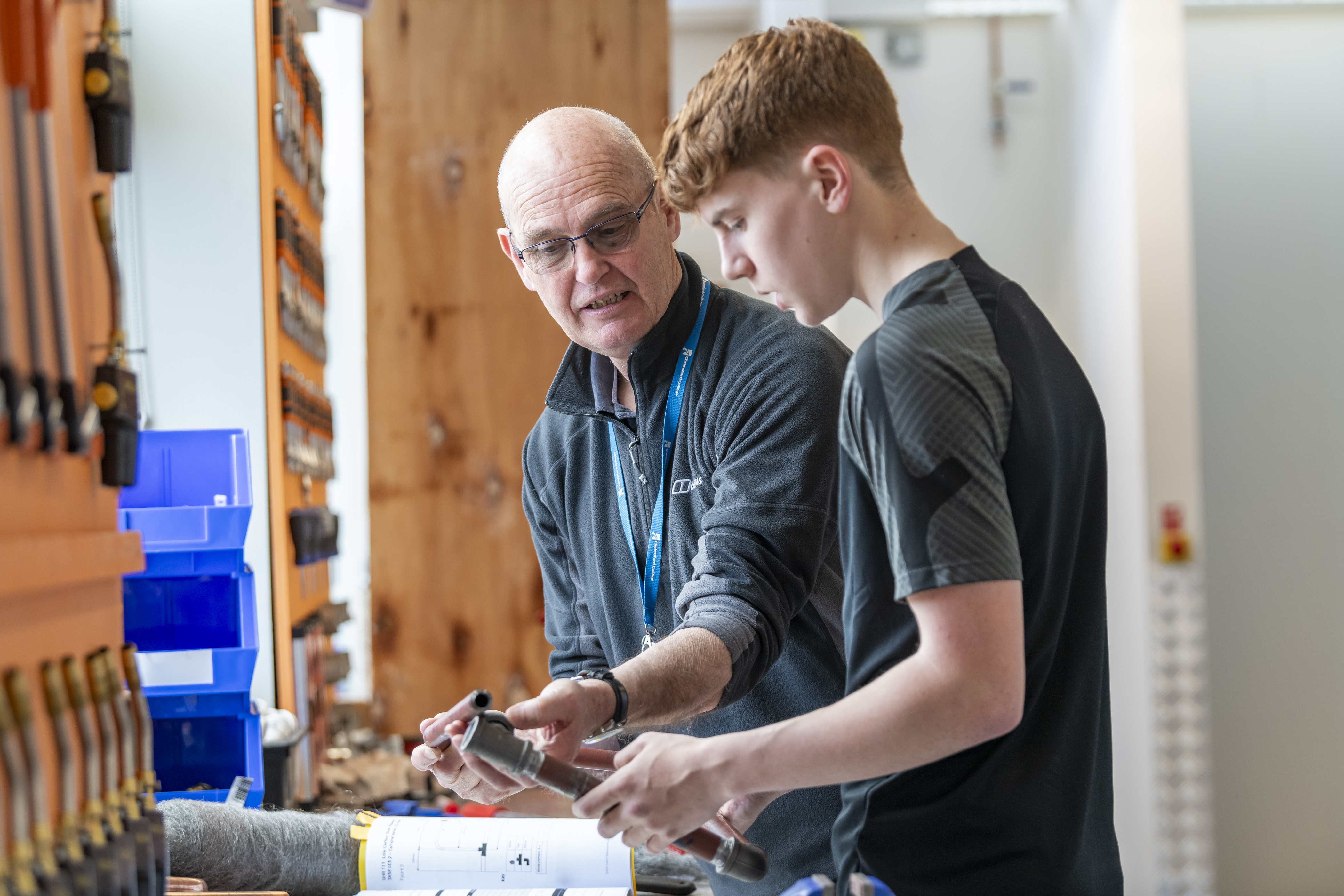A carpentry student measuring timber in a workshop